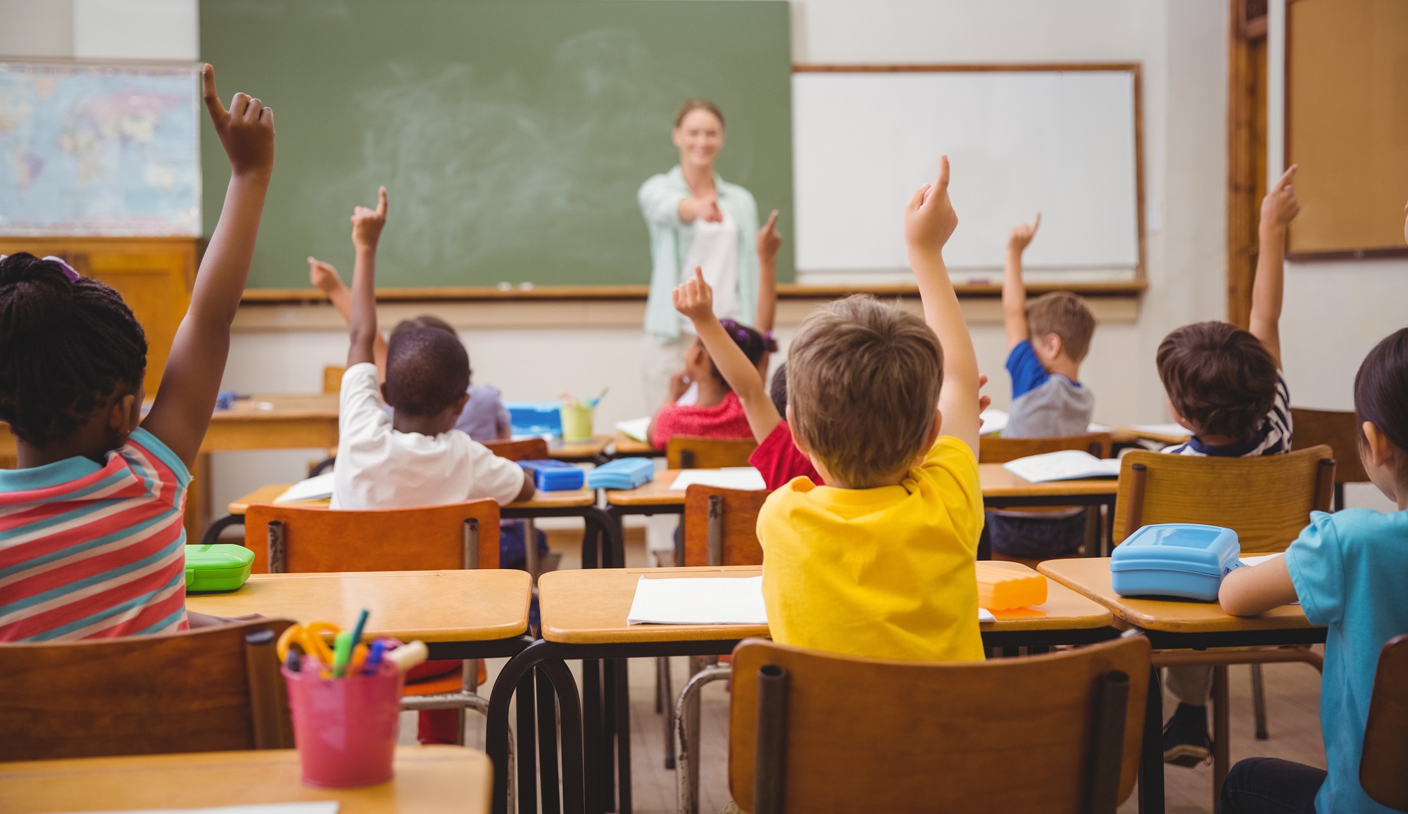 Foto van kinderen in klas die hun hand opsteken