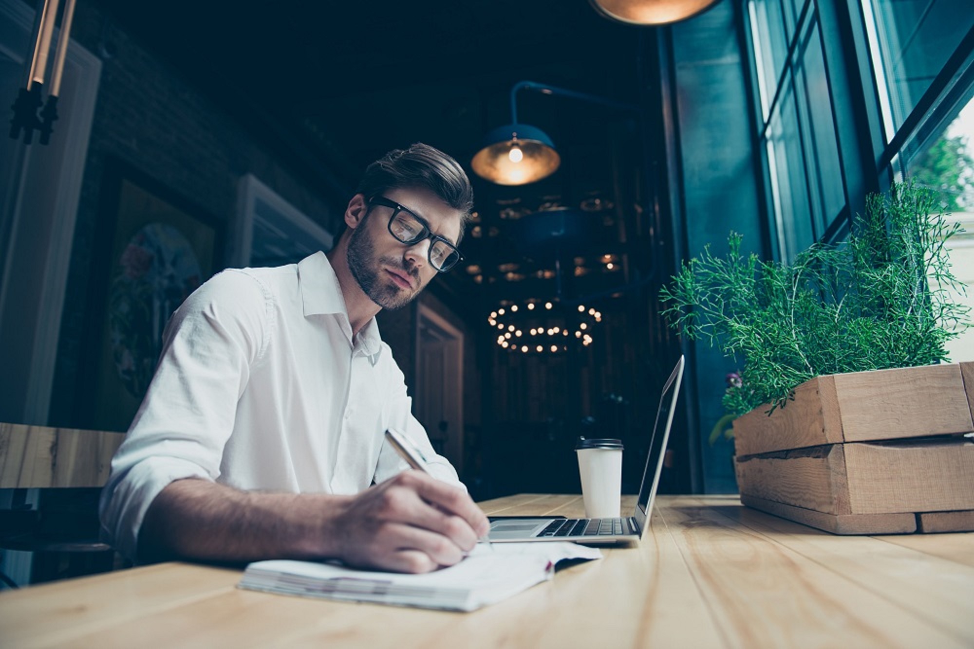 Foto man met laptop en notitieblok