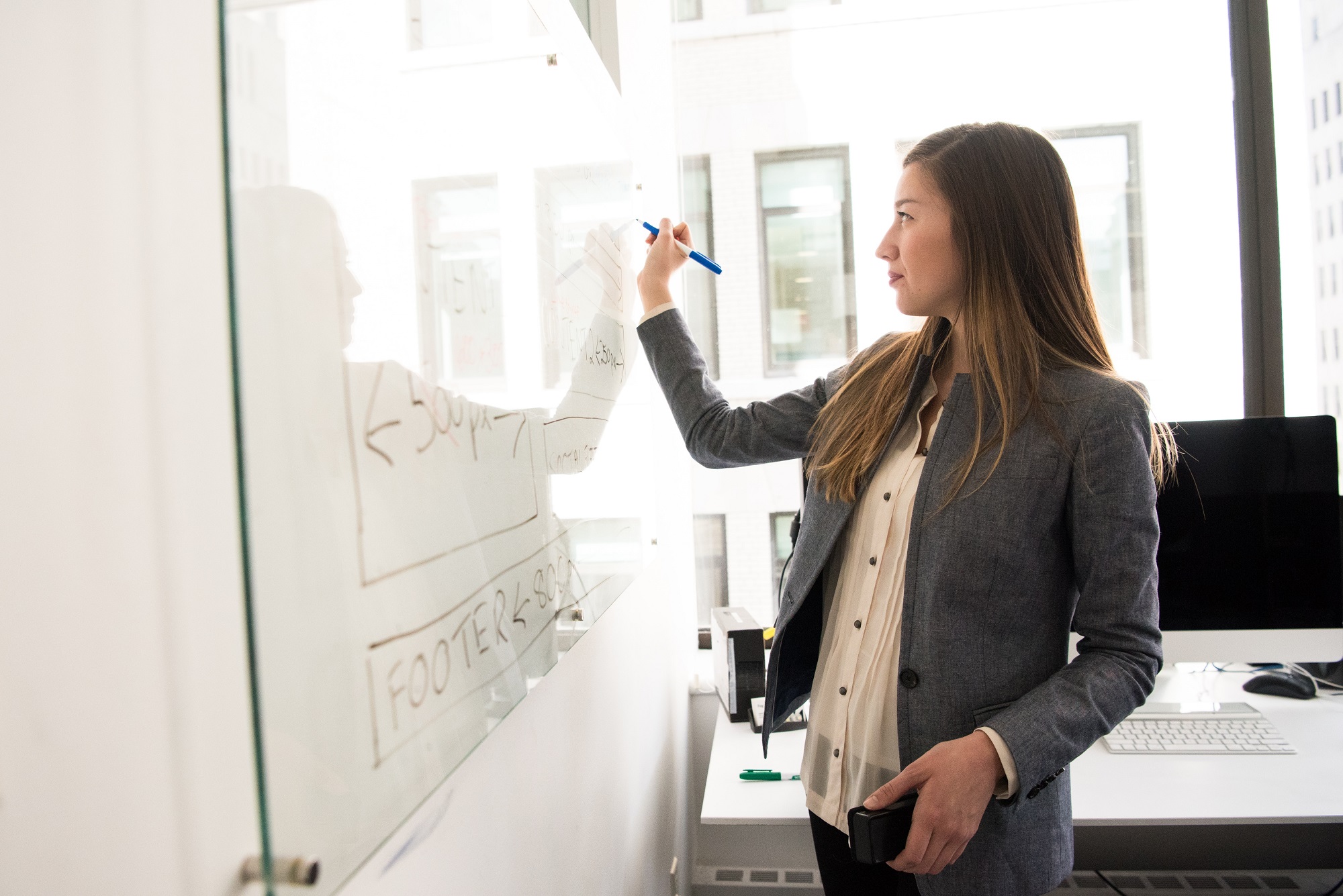 Foto van vrouw die op whiteboard schrijft